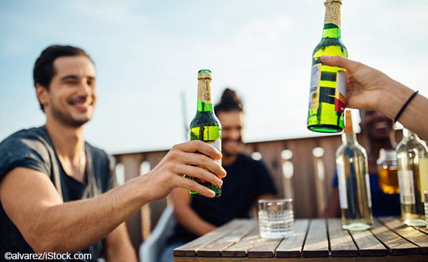 Zwei Personen stoßen mit Bier an