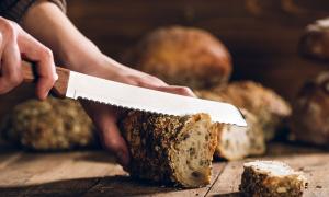 Hände schneiden Brot