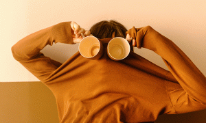 Person mit Kaffeebechern vor den Augen