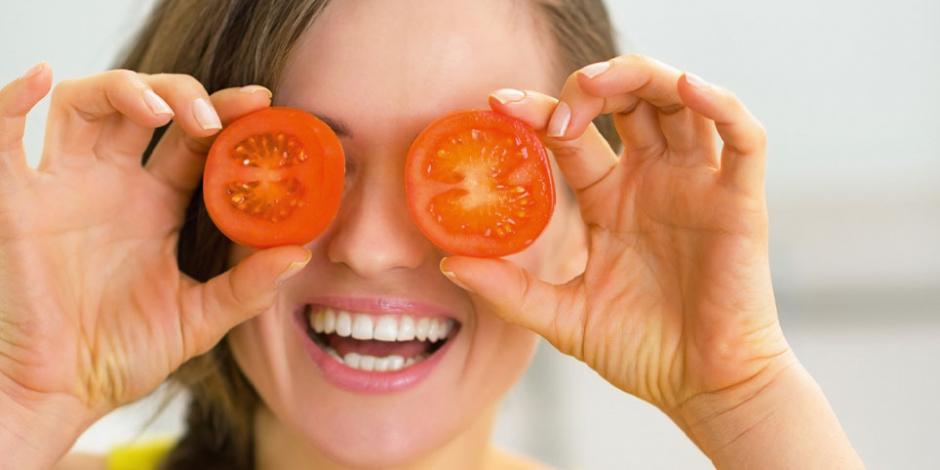 Junge Frau mit Tomaten auf den Augen