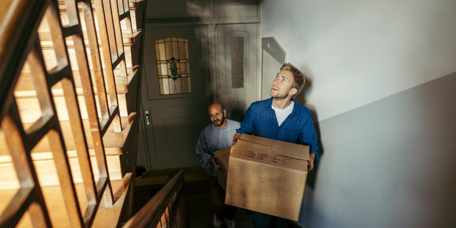 Männer mit Umzugskartons in einem Treppenhaus