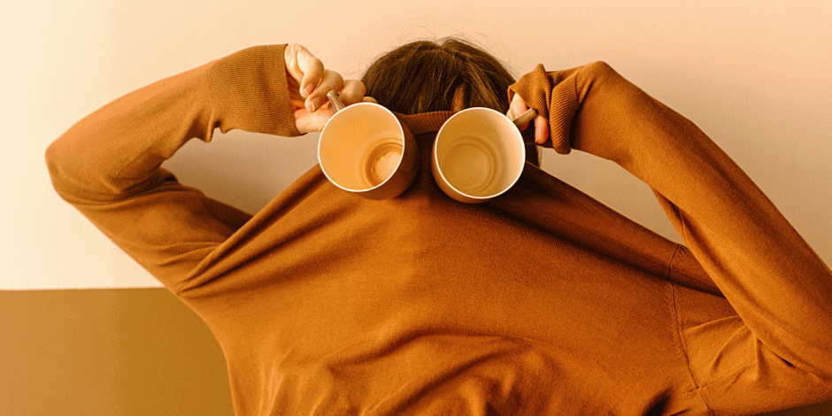 Person mit Kaffeebechern vor den Augen