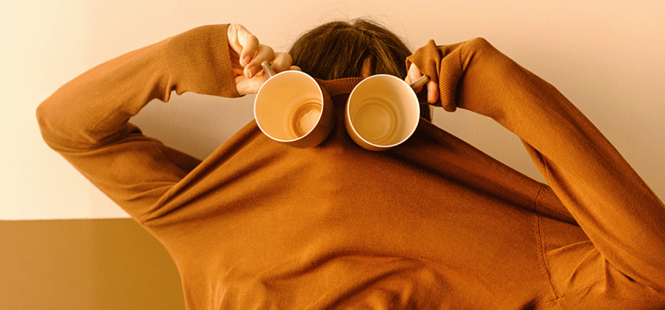Person mit Kaffeebechern vor den Augen