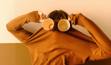 Person mit Kaffeebechern vor den Augen